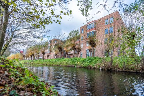 Achterzijde pand Lakenhof in het groen aan het water